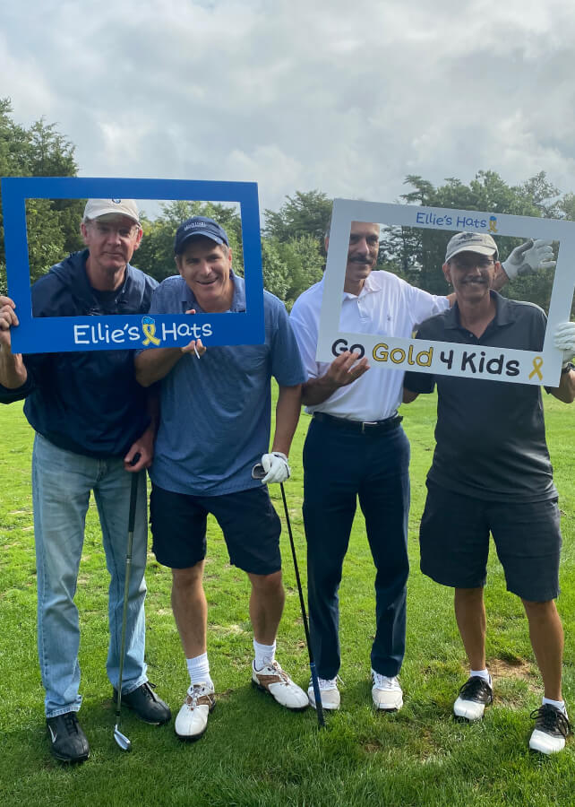 Golfers holding Ellie’s Hats and Go Gold 4 Kids photo frames at the 2024 Classic